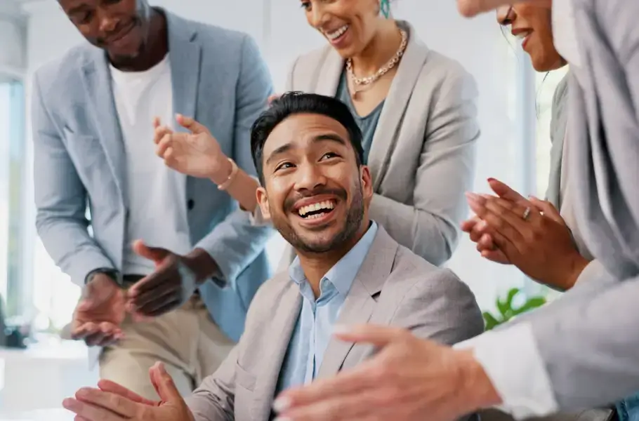 Group of people clapping and smiling at a man