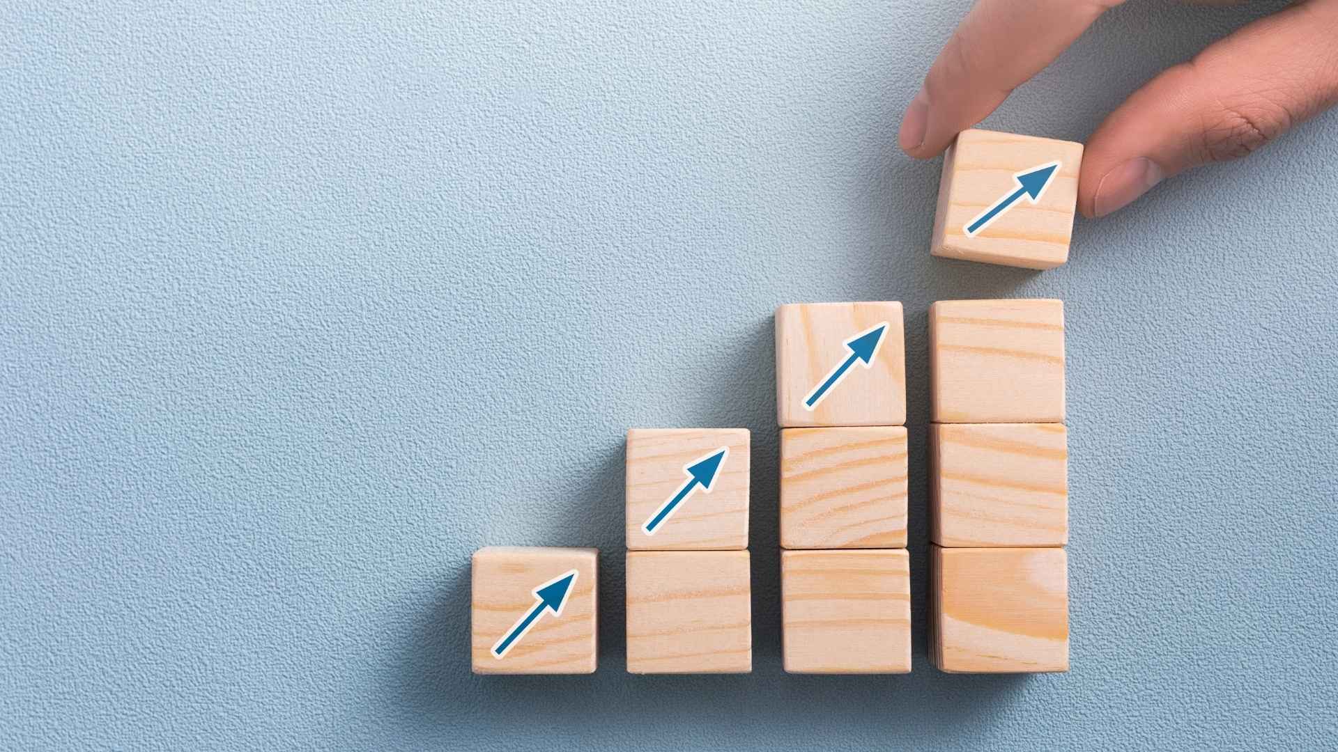 hand arranging wood block with arrow icon