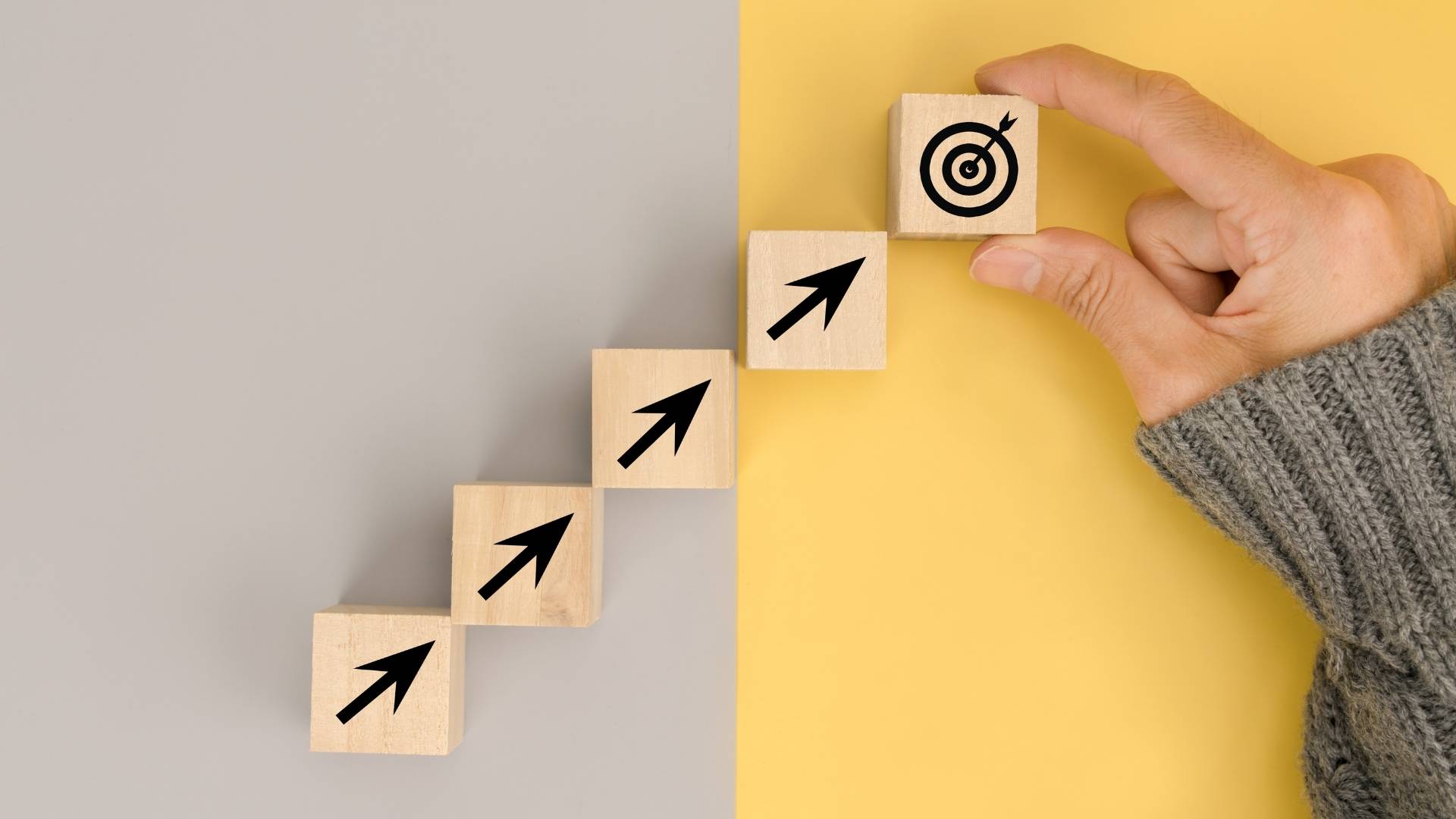 hand arranging wood blocks with business icons