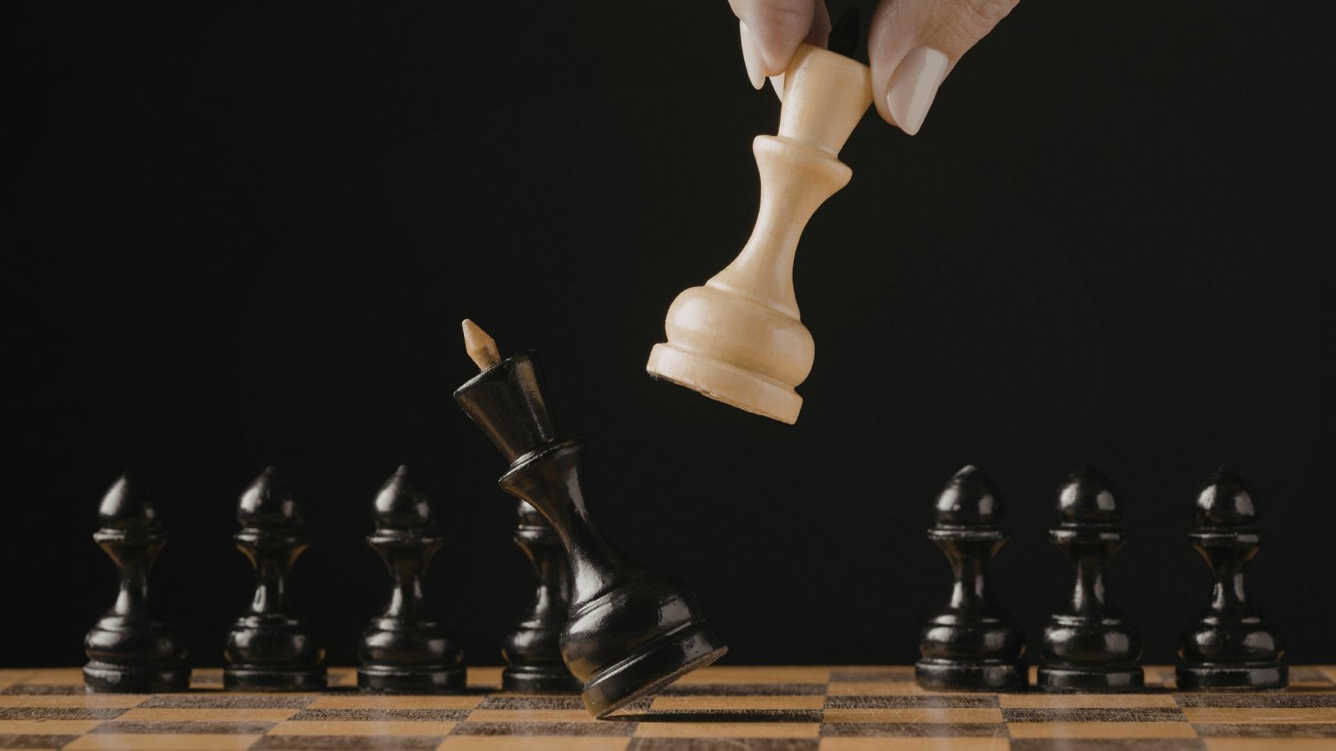 hand moving chess piece over board