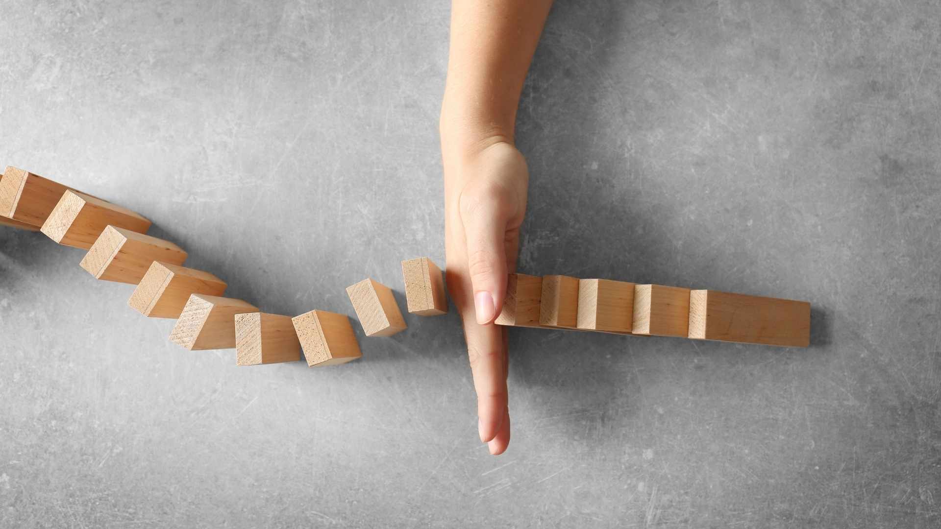 hand stopping domino effect