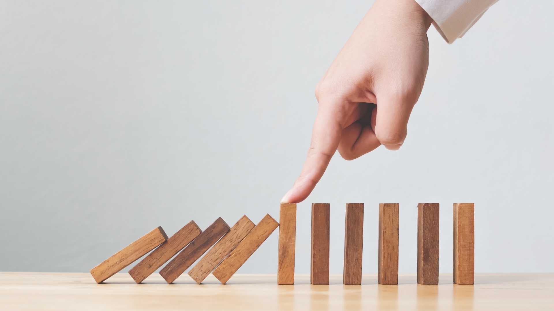 hand stopping wooden blocks to fall