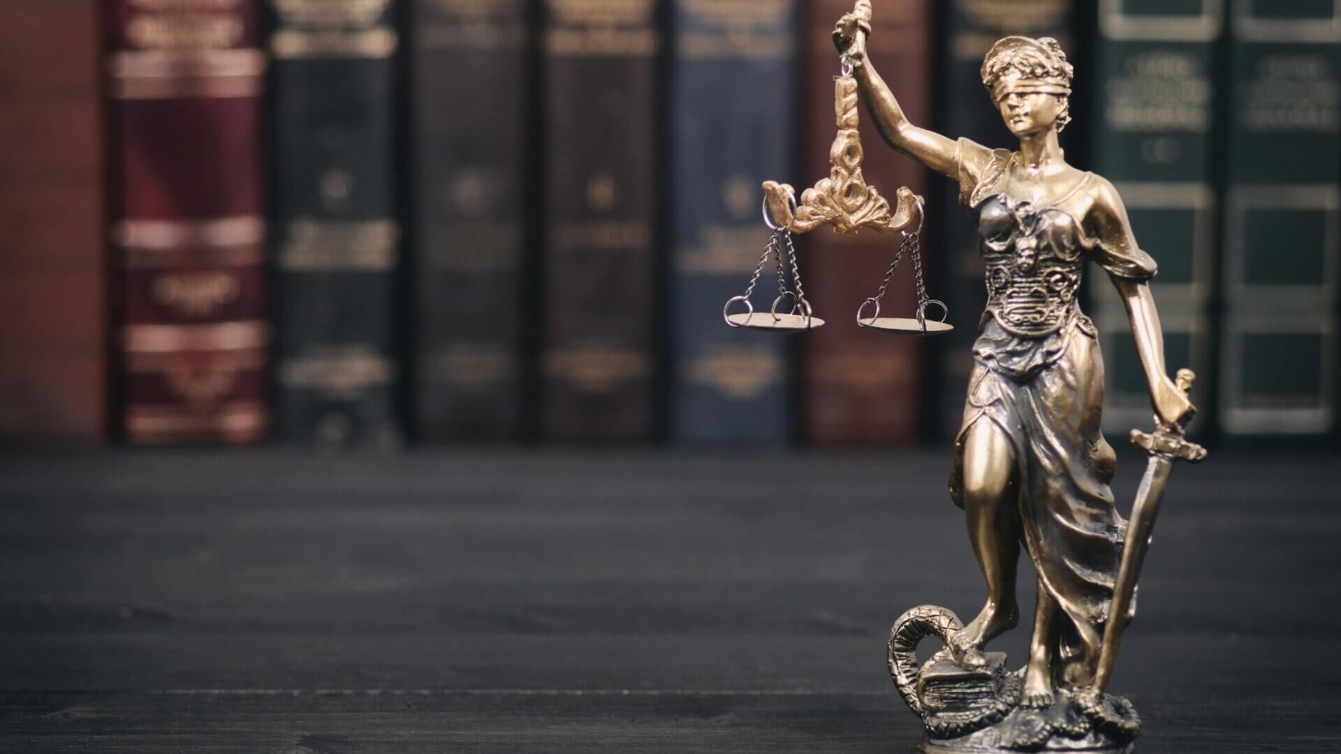 lady justice law figurine in front of legal books