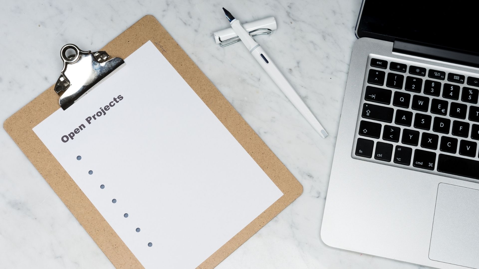 laptop pen and a noteboard