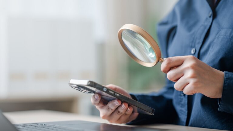 magnifying glass on phone checking the design of homepage