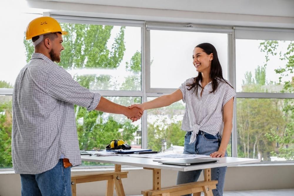 male contractor with client shaking hands