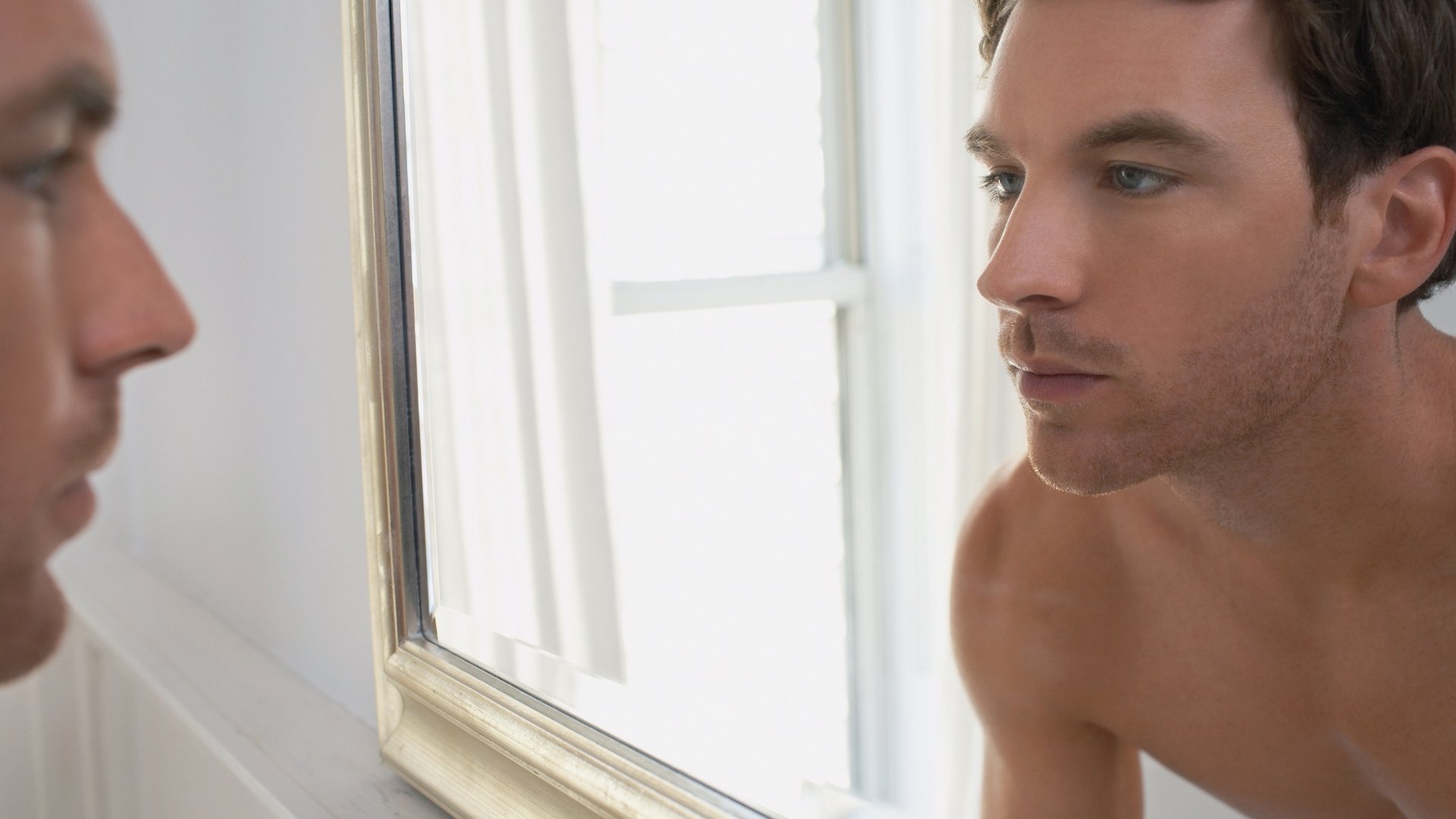 man facing his self in the mirror