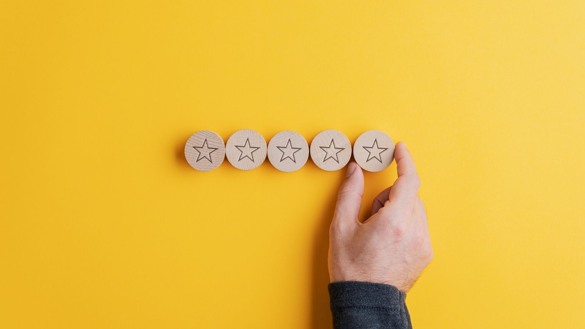 man lining up wooden circles with stars carved