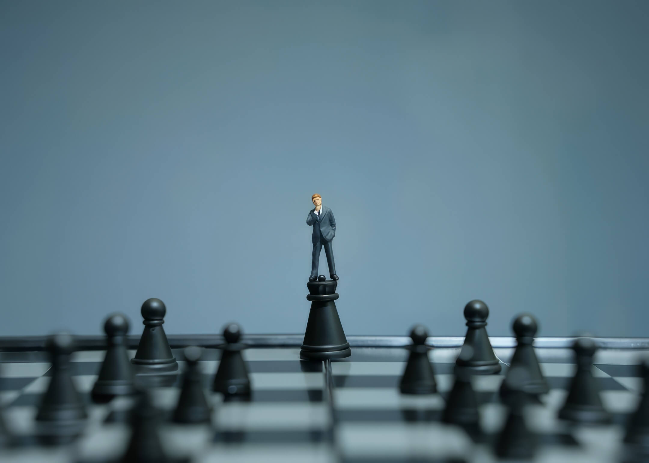 man on top of a chess piece while viewing the whole chessboard