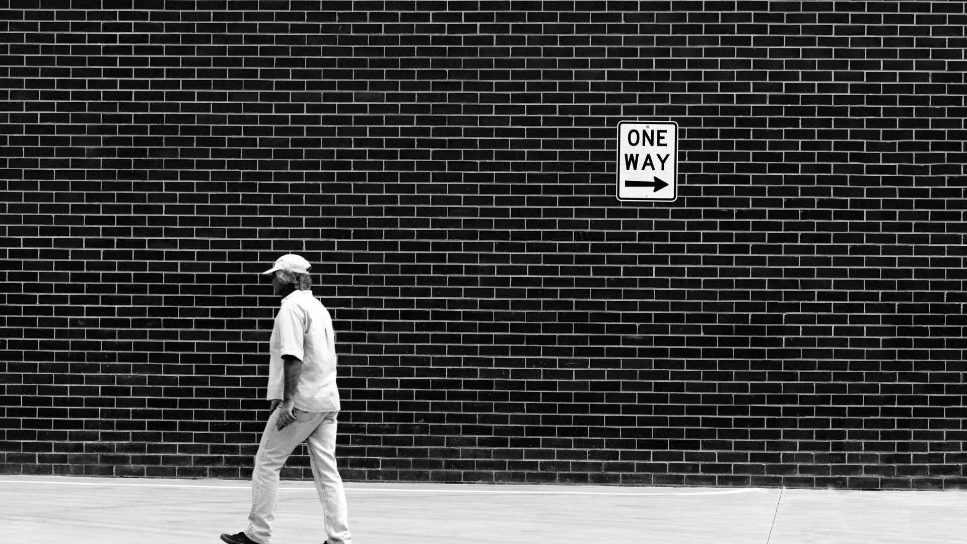man walking in the opposite direction of a signage