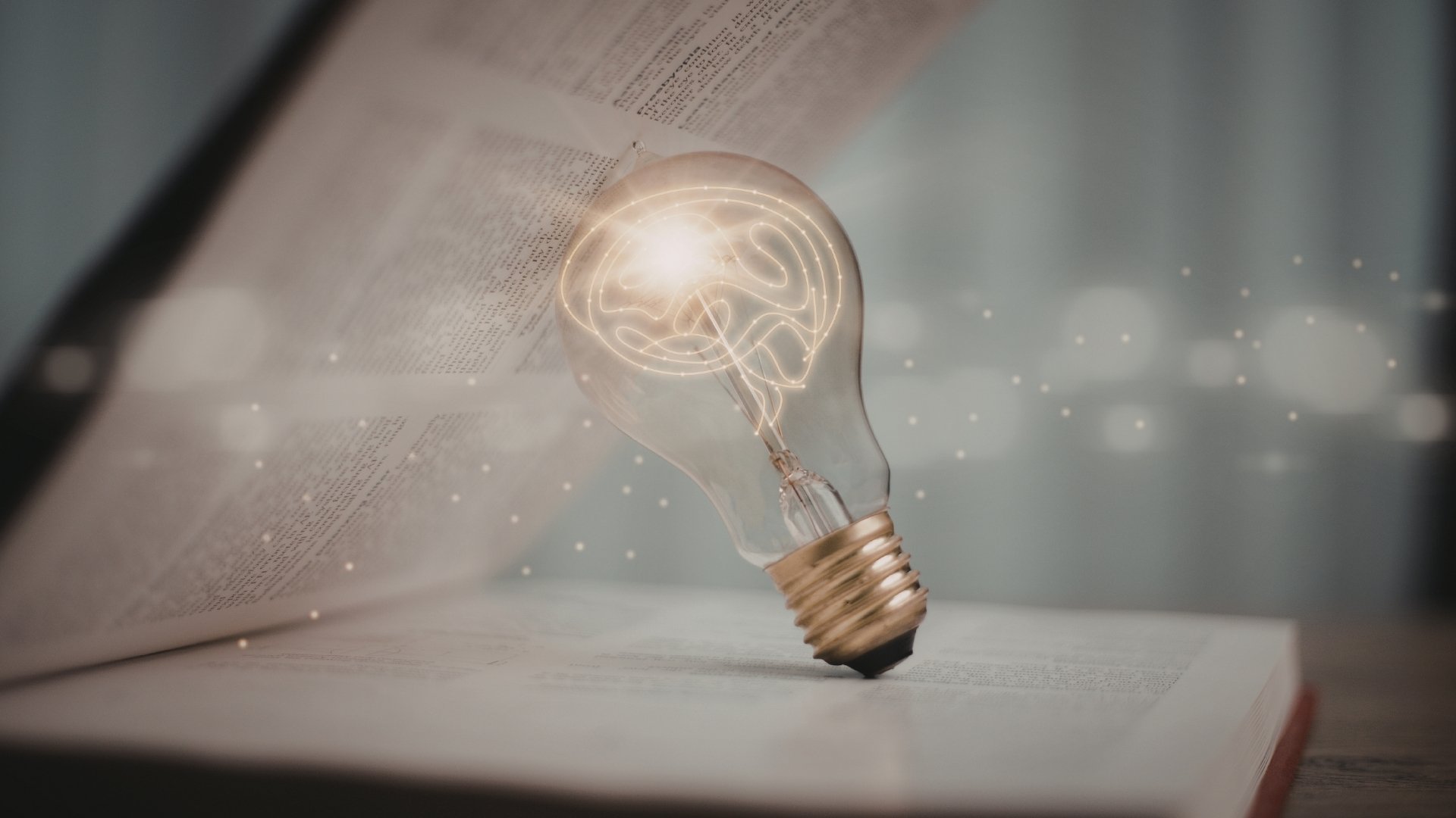 open book with glowing light bulb