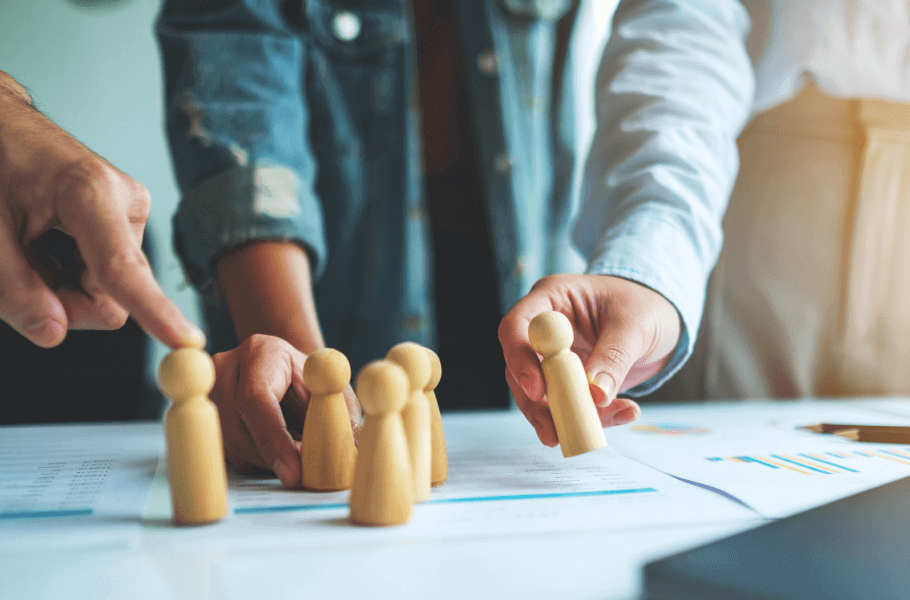 People arranging wooden figures on a desk with documents