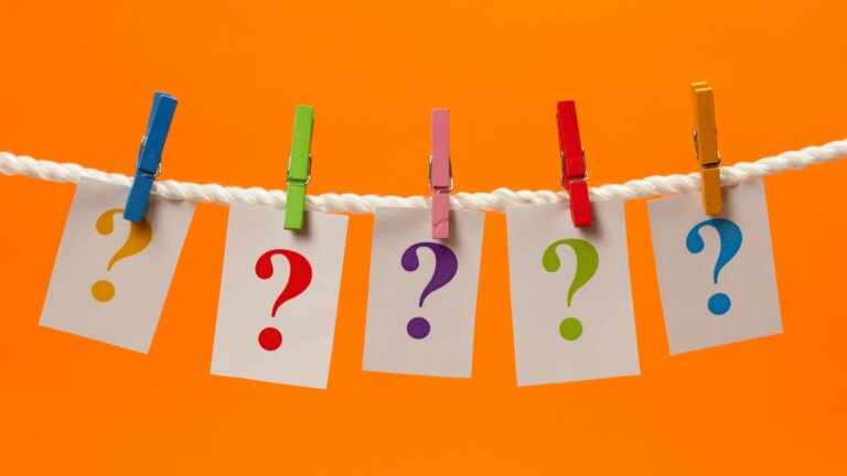 question marks on paper hanging on clothesline