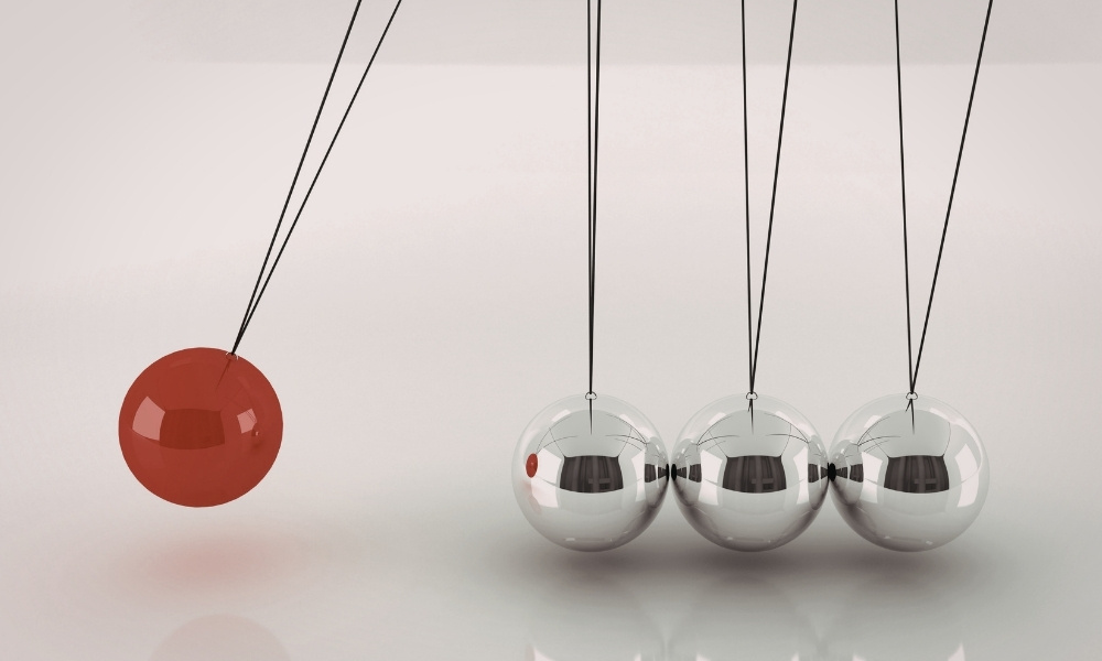 red ball hitting several stacked gray balls
