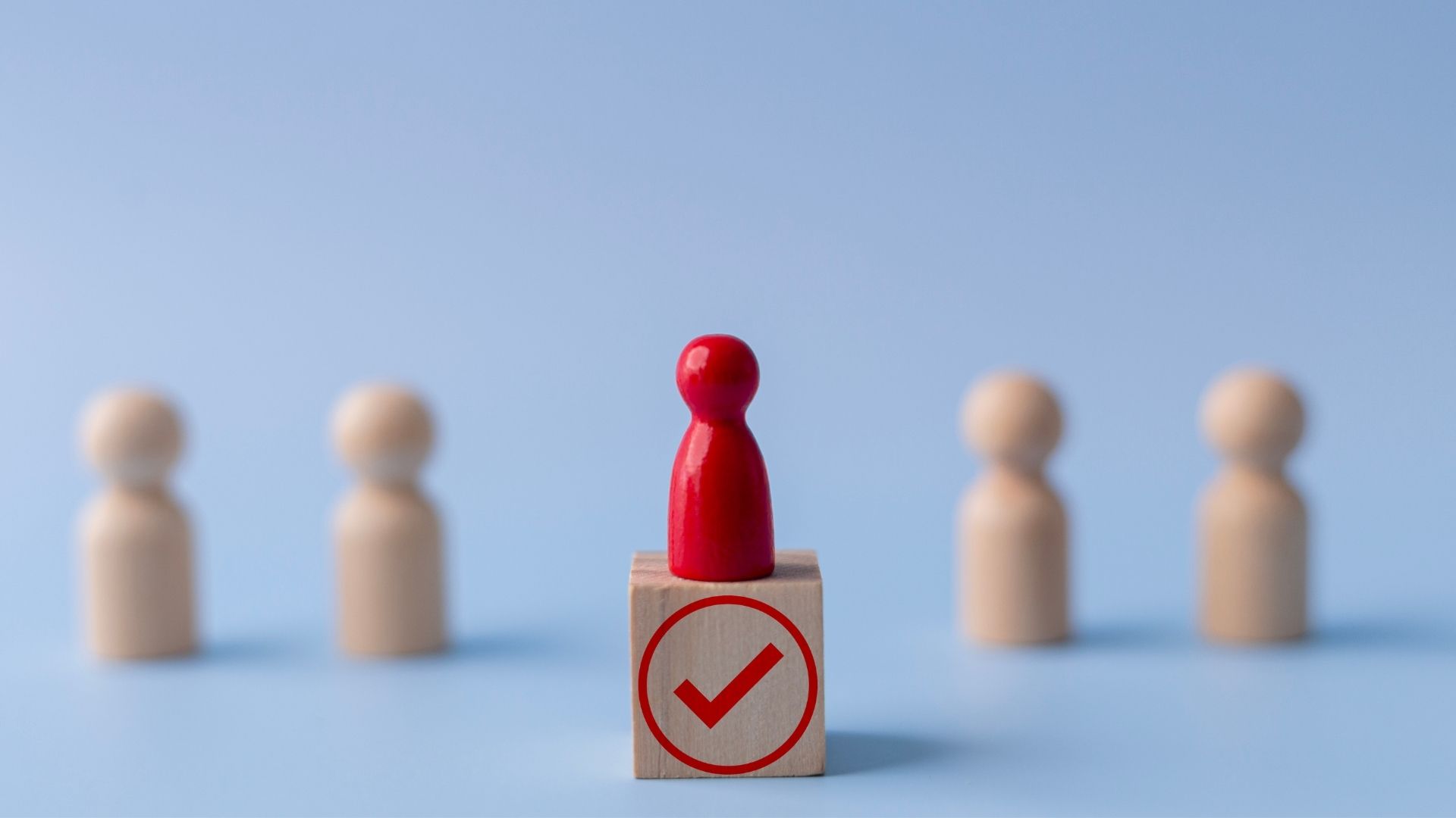 red wooden figure highlighted among the rest