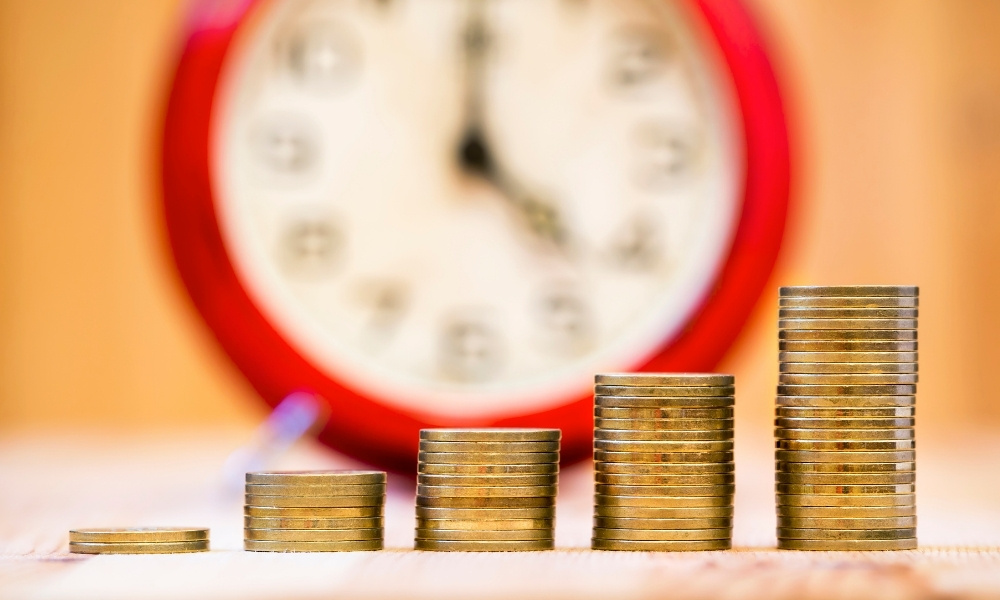 several coins stacks in front of a clock