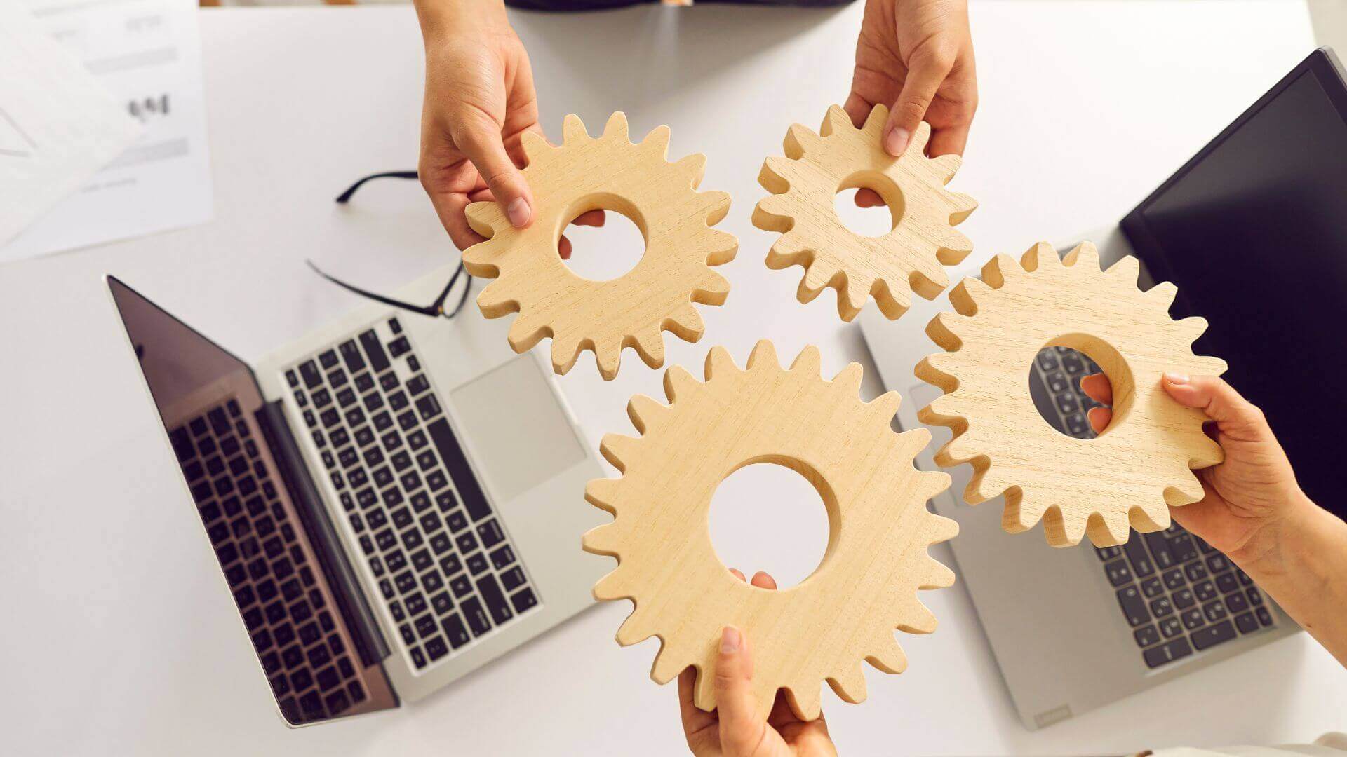 team members holding a wooden cogs