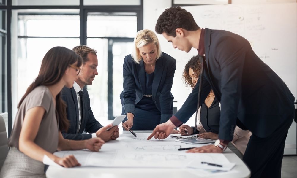 team of professional brainstorming on a new redesign in blueprints