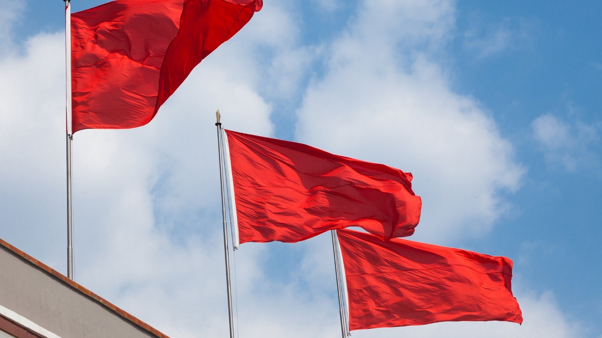 three red flags on top of buildings