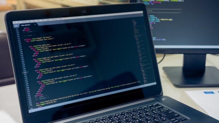 two computers fixing website bugs