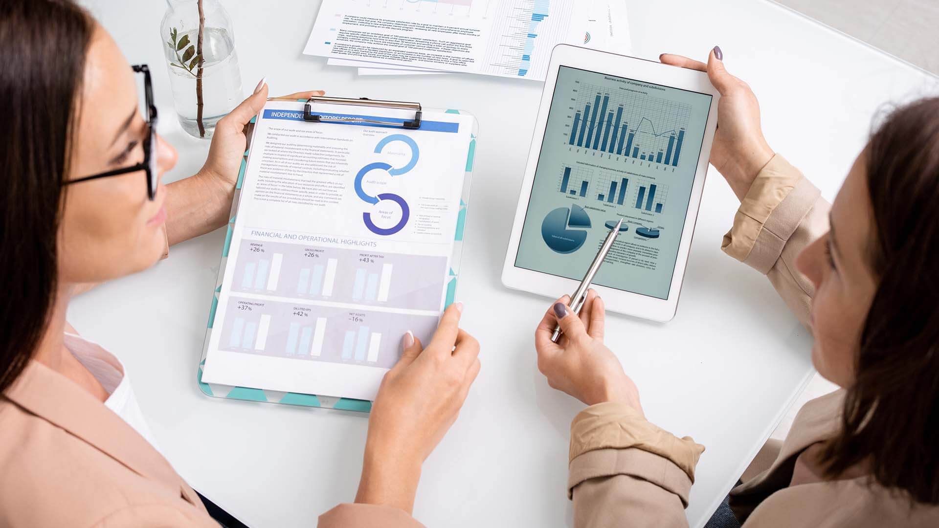 two-young-businesswomen-analyzing-and-discussing