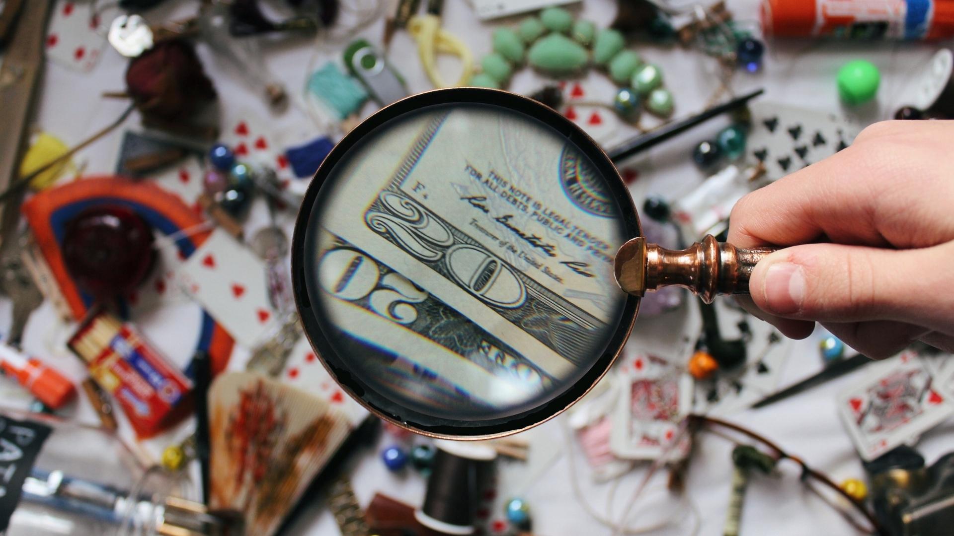using magnifying glass to find the dollar bill