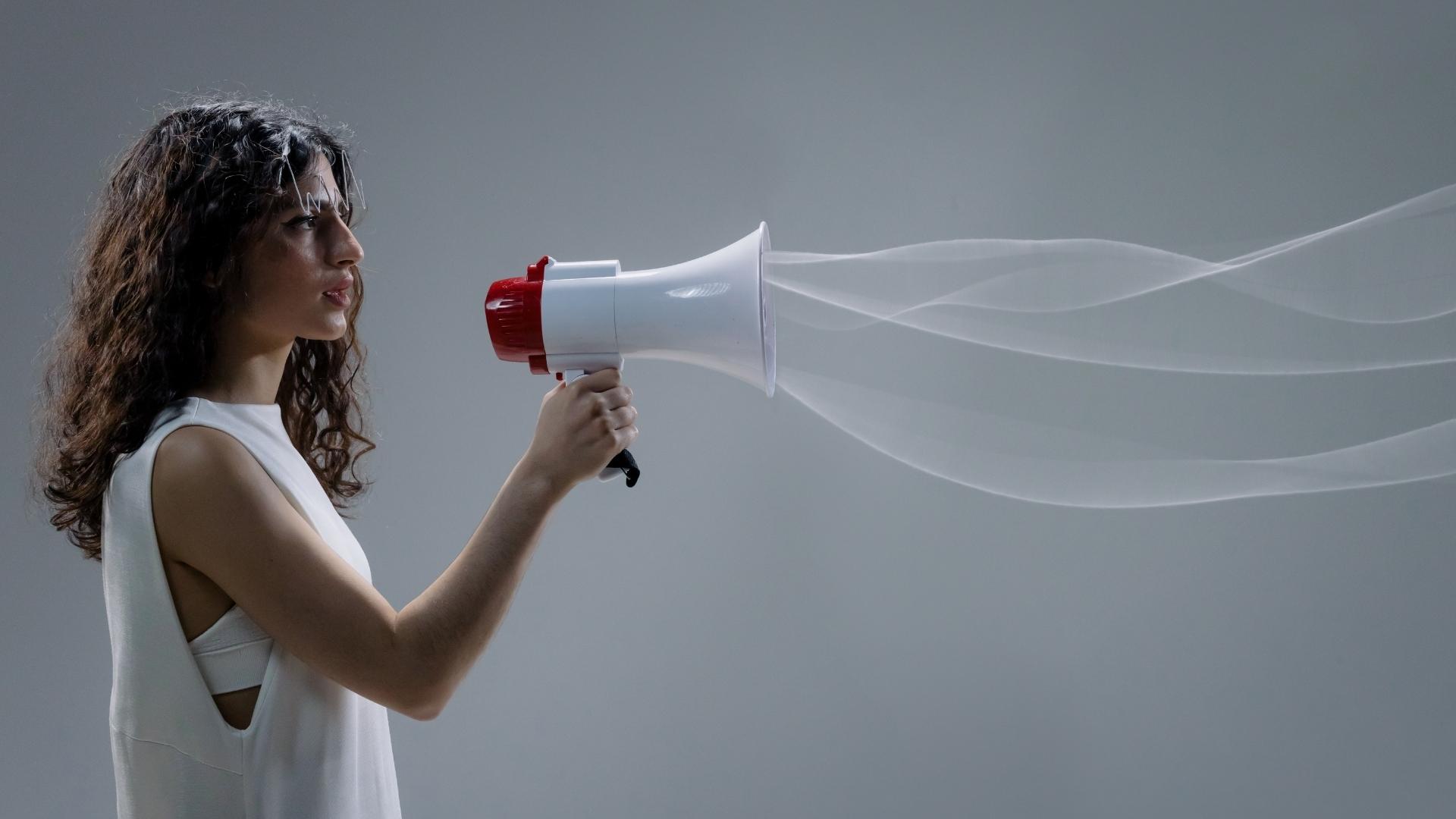 wavy haired woman holding a megaphone