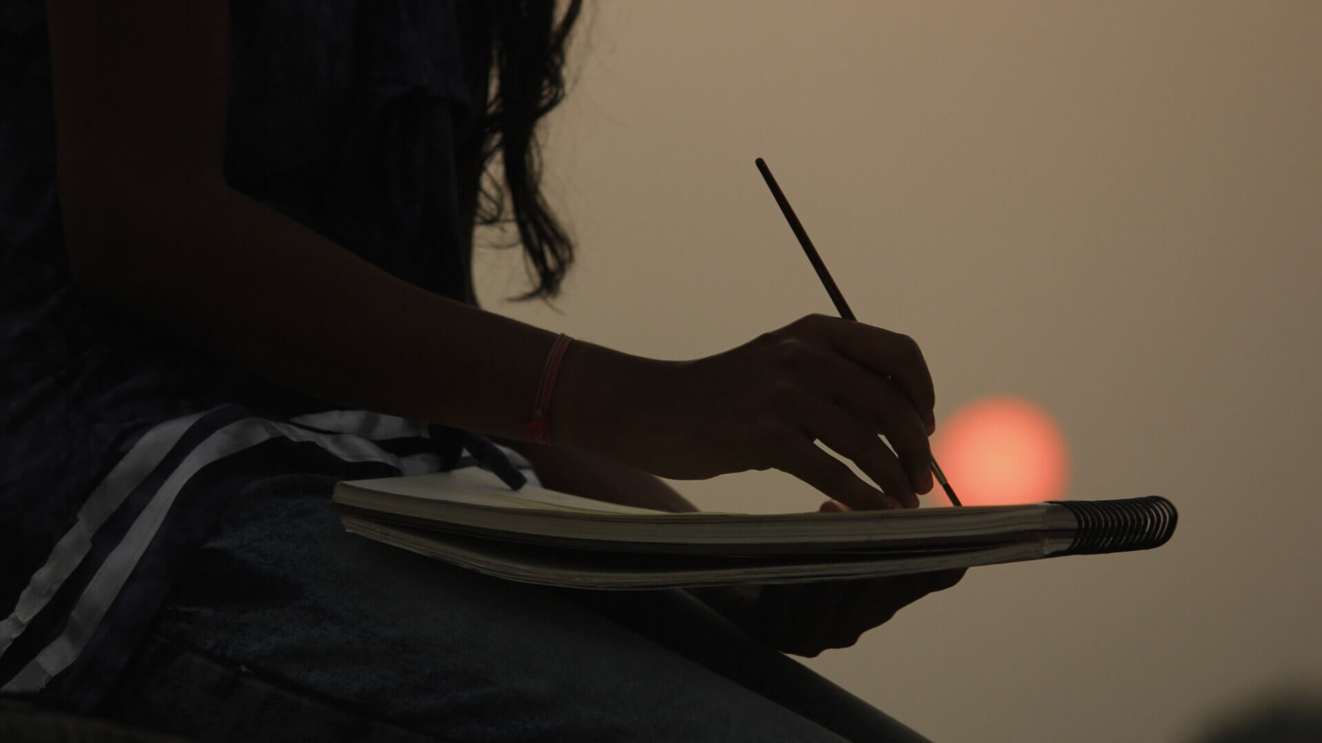 woman drawing under the sunset