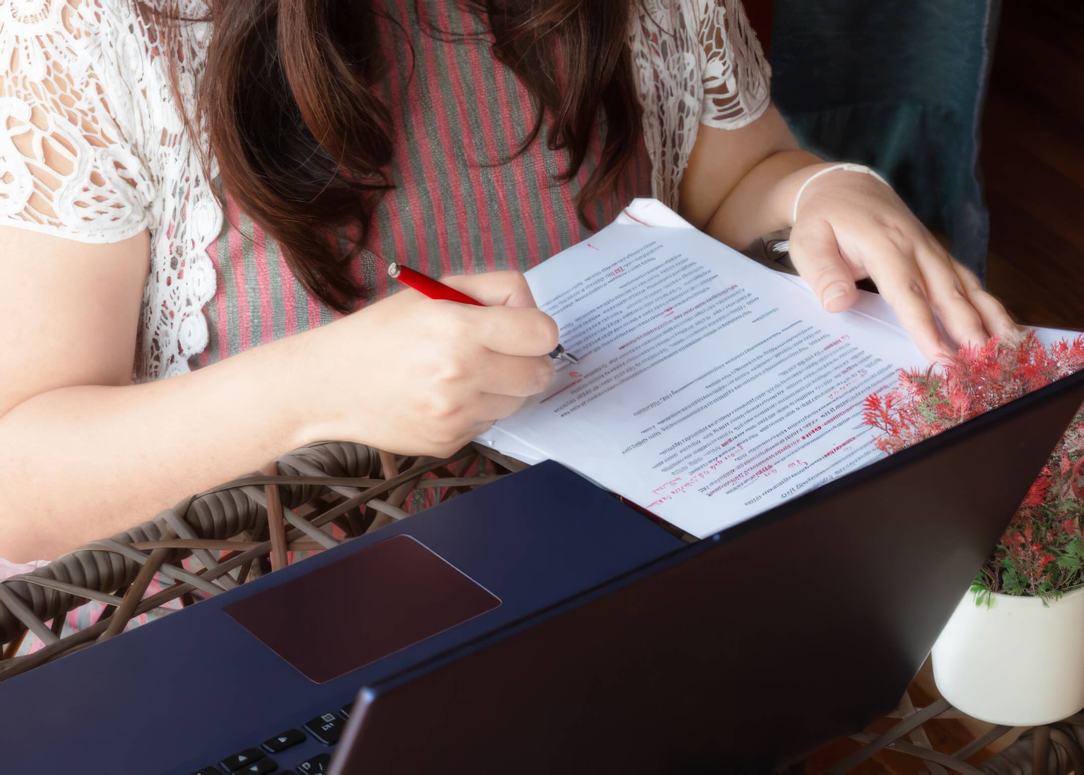 woman holding pen fixing grammatical errors on their blog post