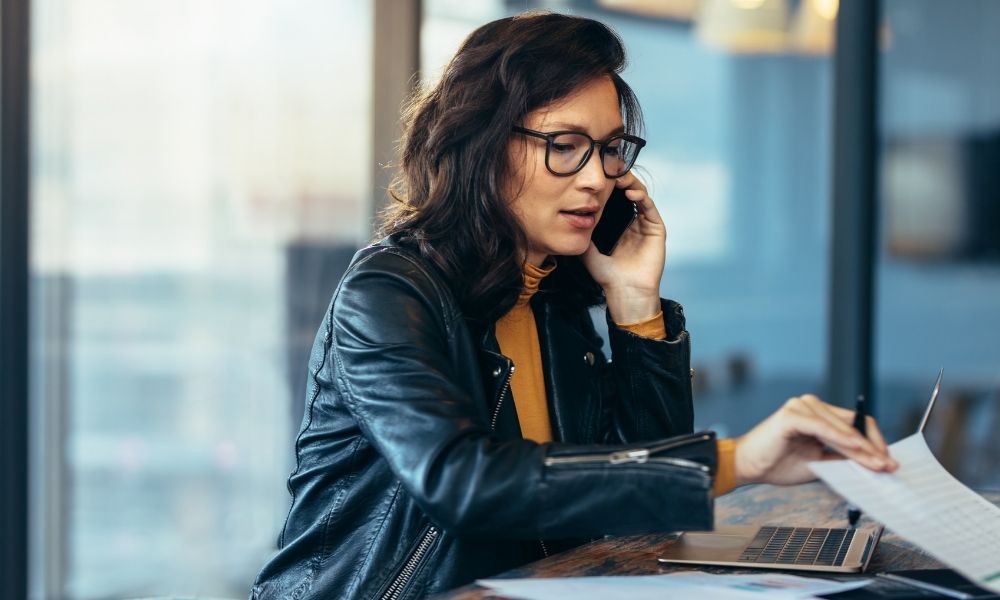 woman writing emails and calling on her phone
