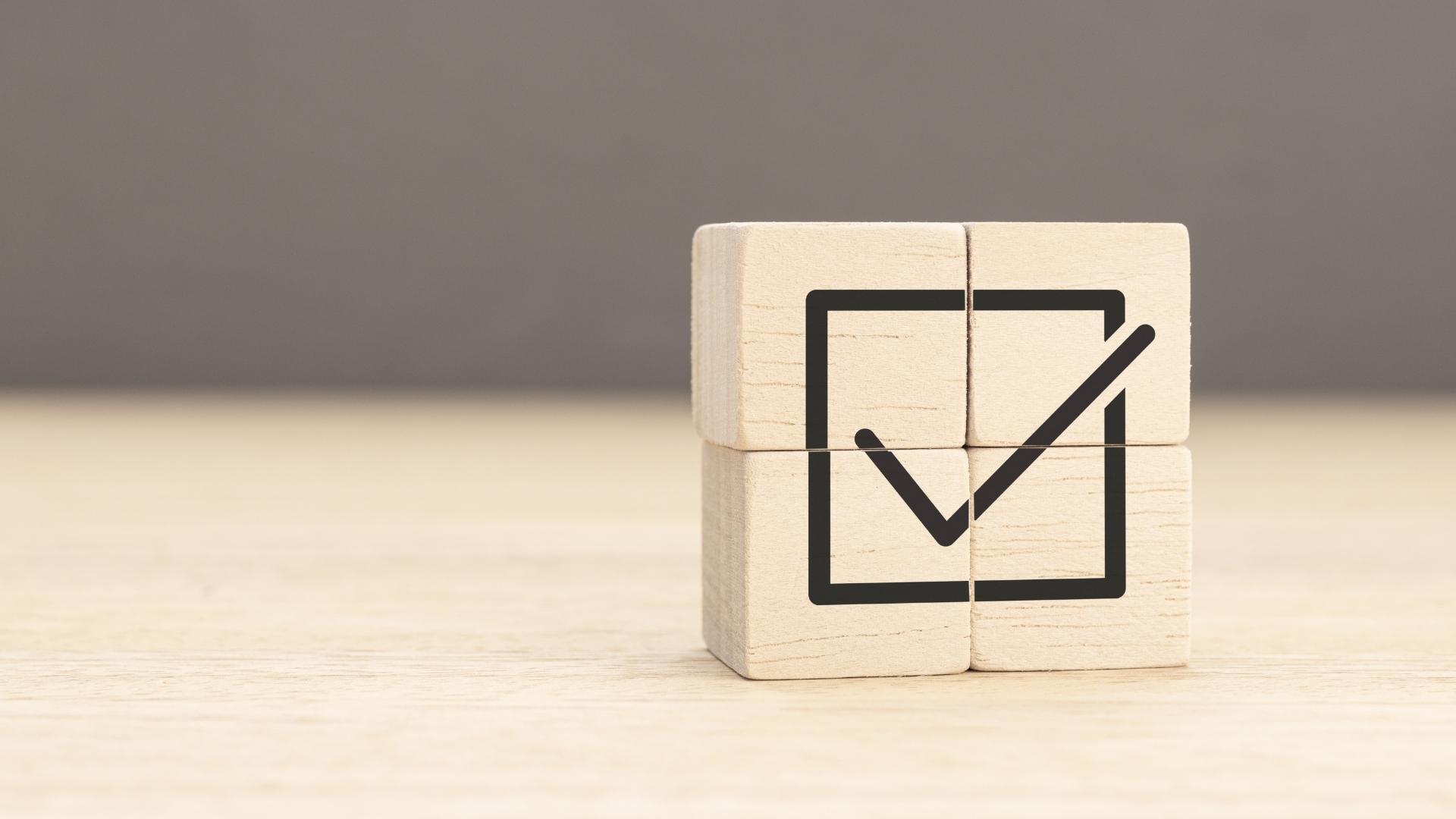 wooden cubes stacked up forming a check symbol