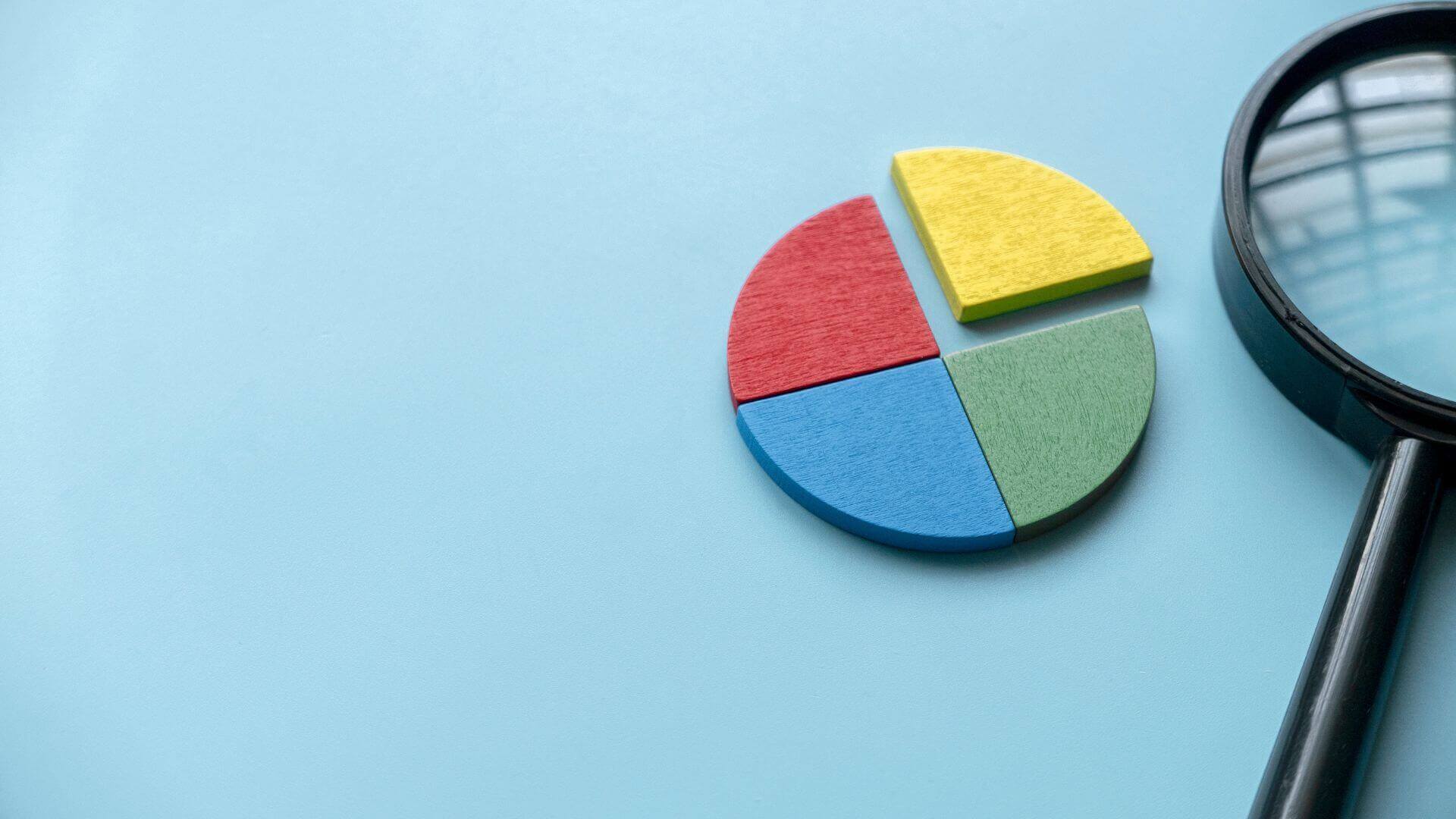 wooden pie chart and a magnifying glass