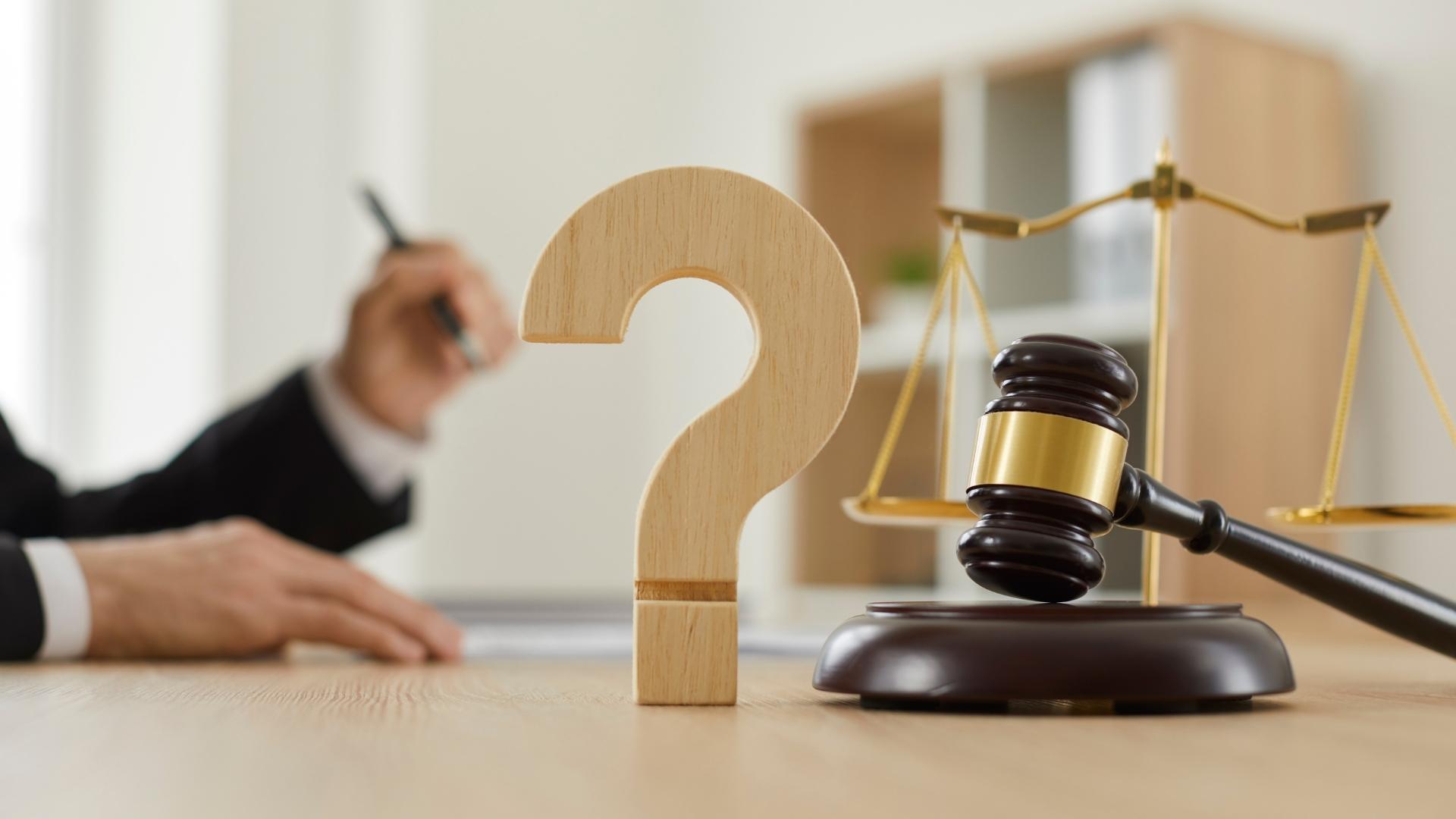 wooden question mark and gavel on the table in the courtroom