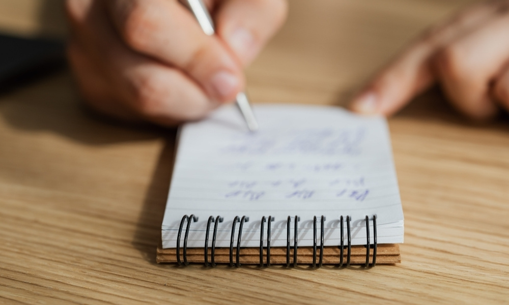 writing notes in a small notebook